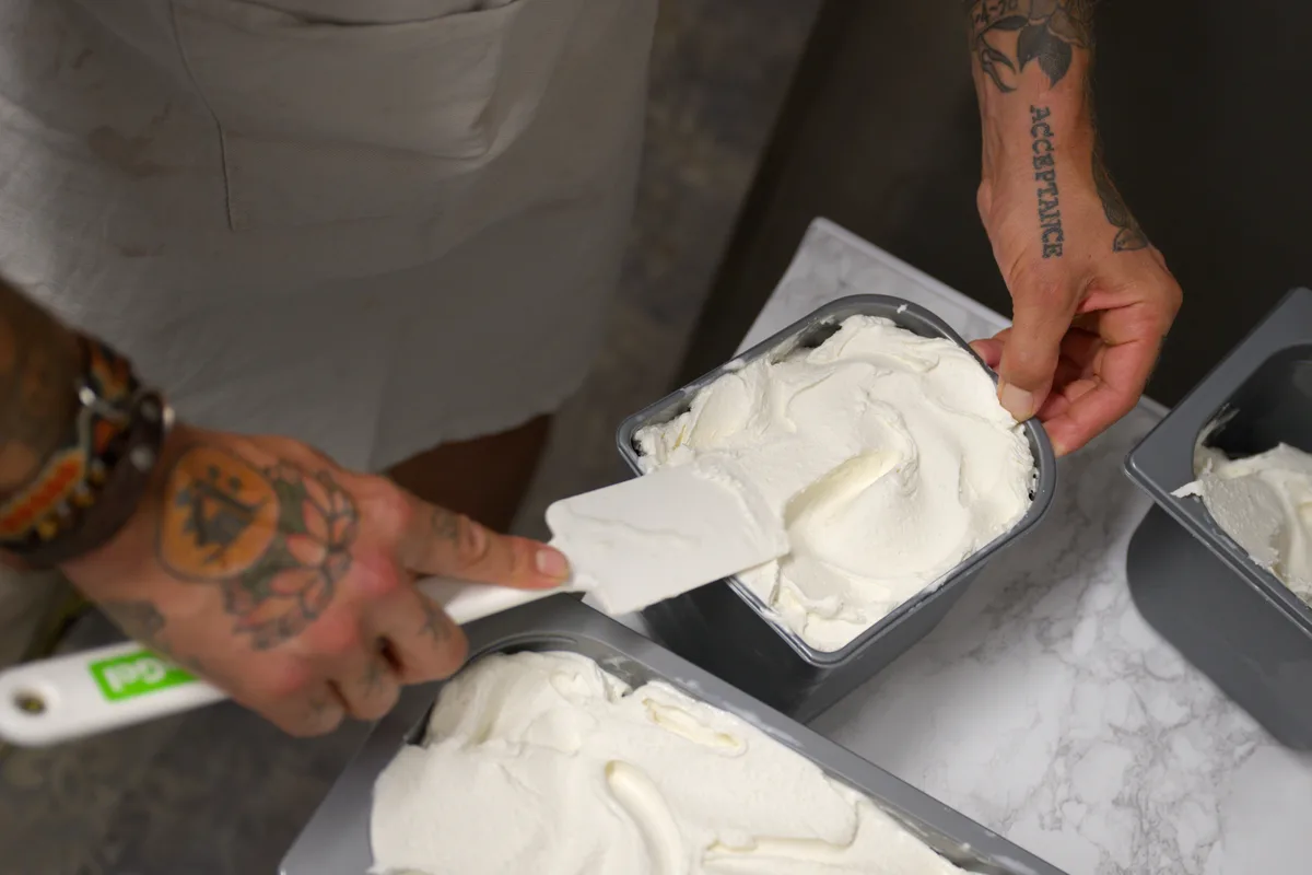 … und nochmals glatt streichen … Ein Mann streicht mit einem Gummischaber über Glace.